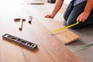 Construction worker measuring floorboards