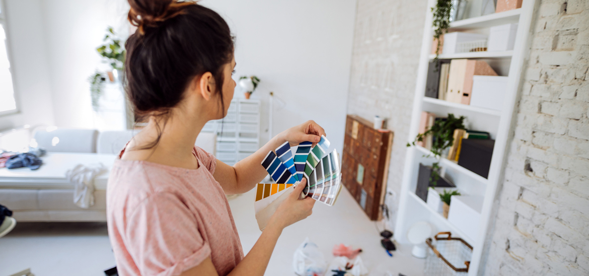 Woman looking at color options for painting a wall