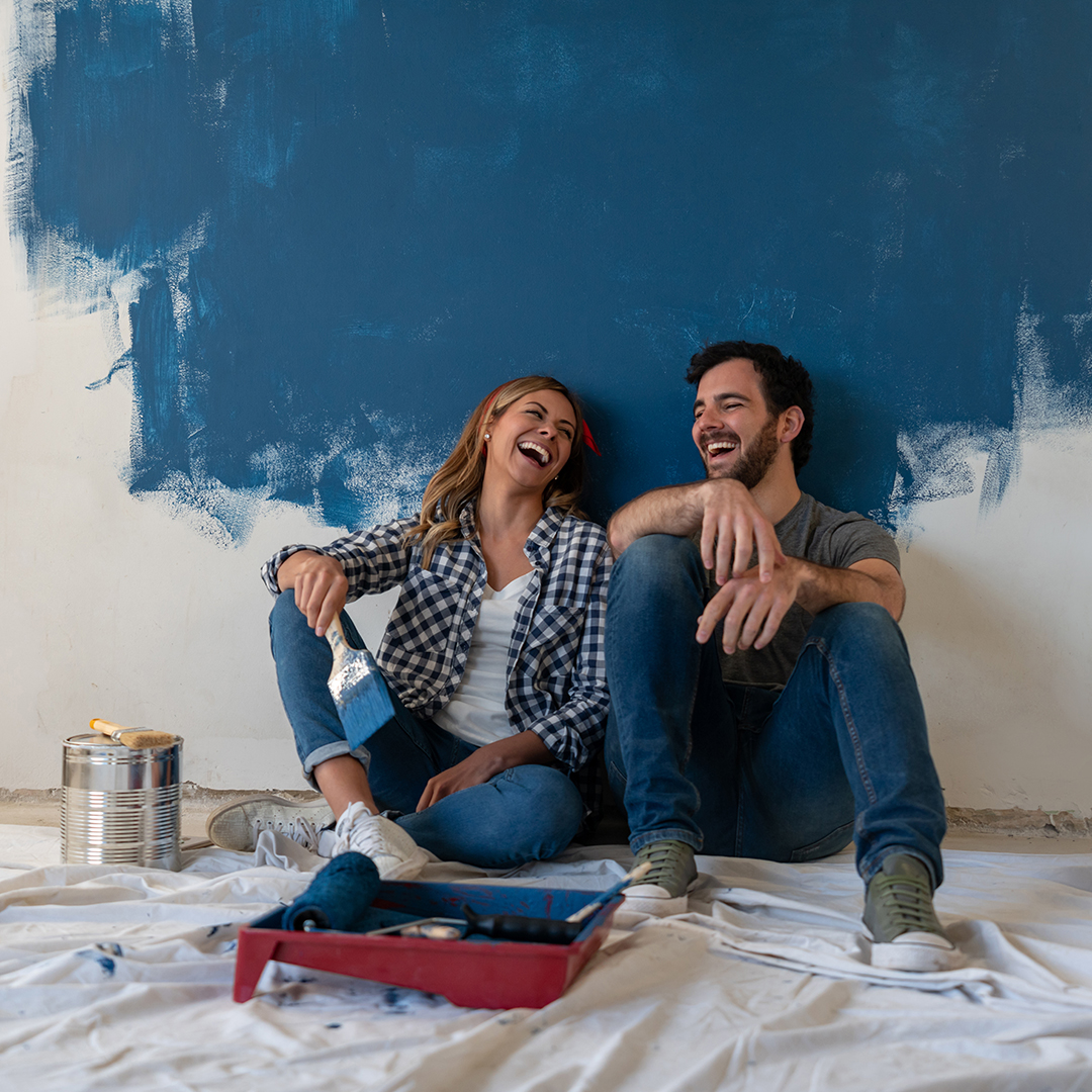 Couple Laughing While Taking a Break from Painting a Room