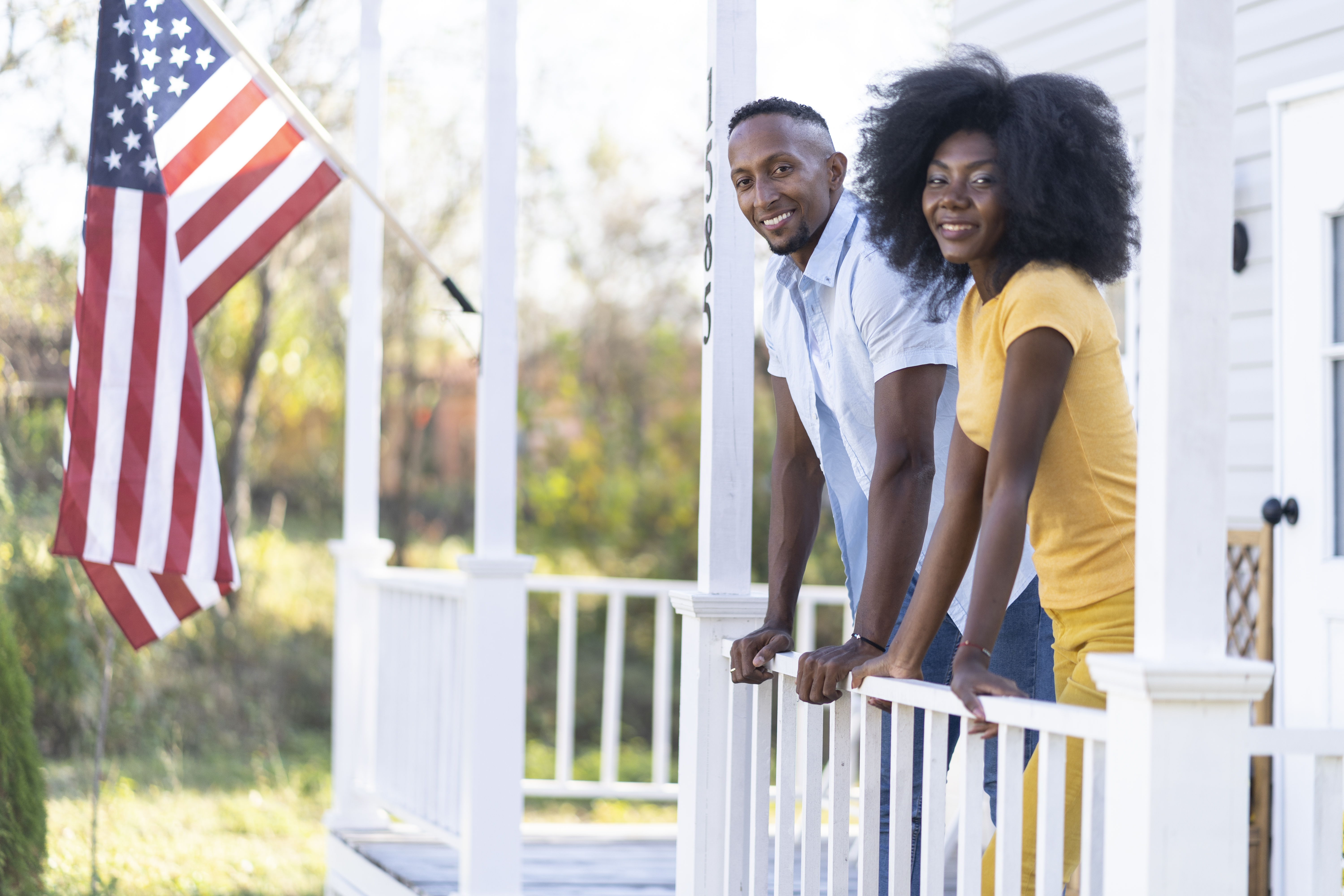 Couple on Front Porch with American Flag in Background