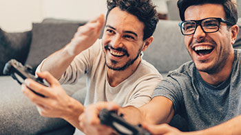 Two men playing videogames and laughing