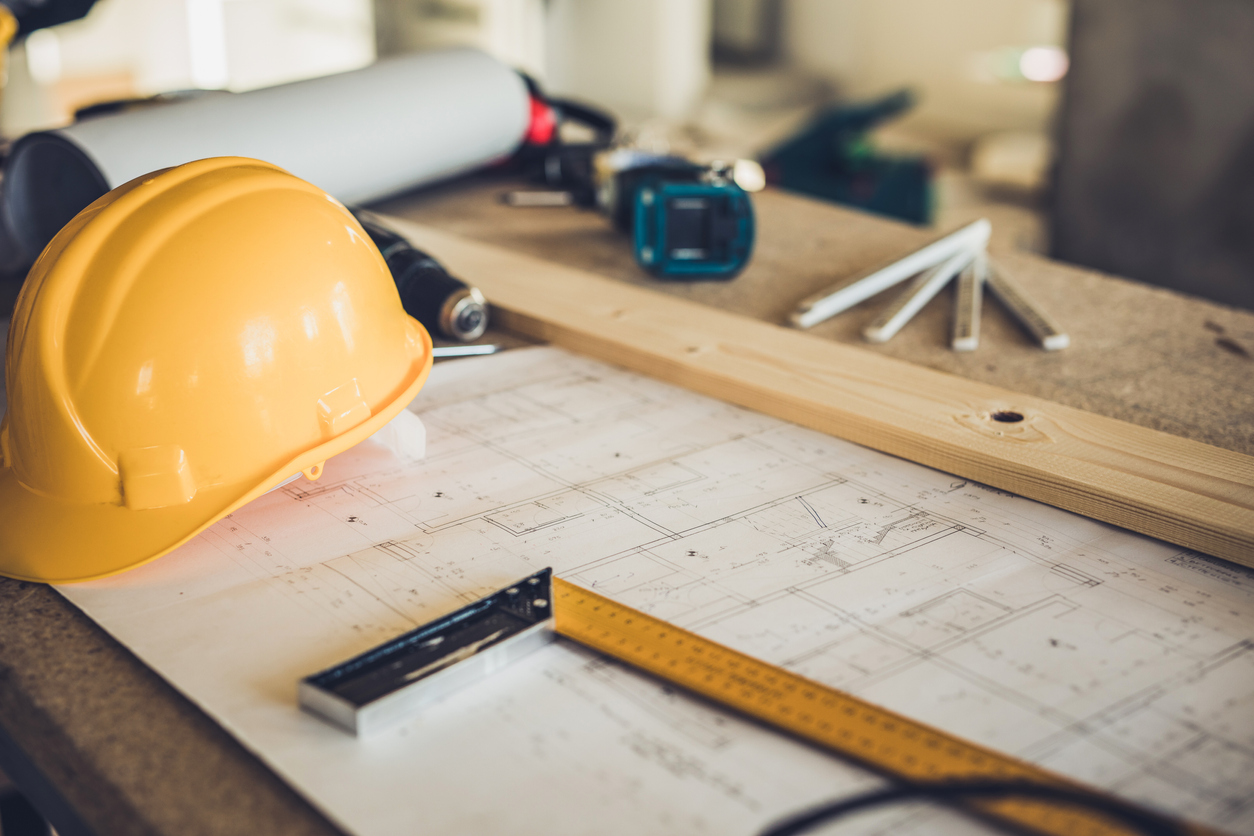 Construction hat on top of table covered in tools