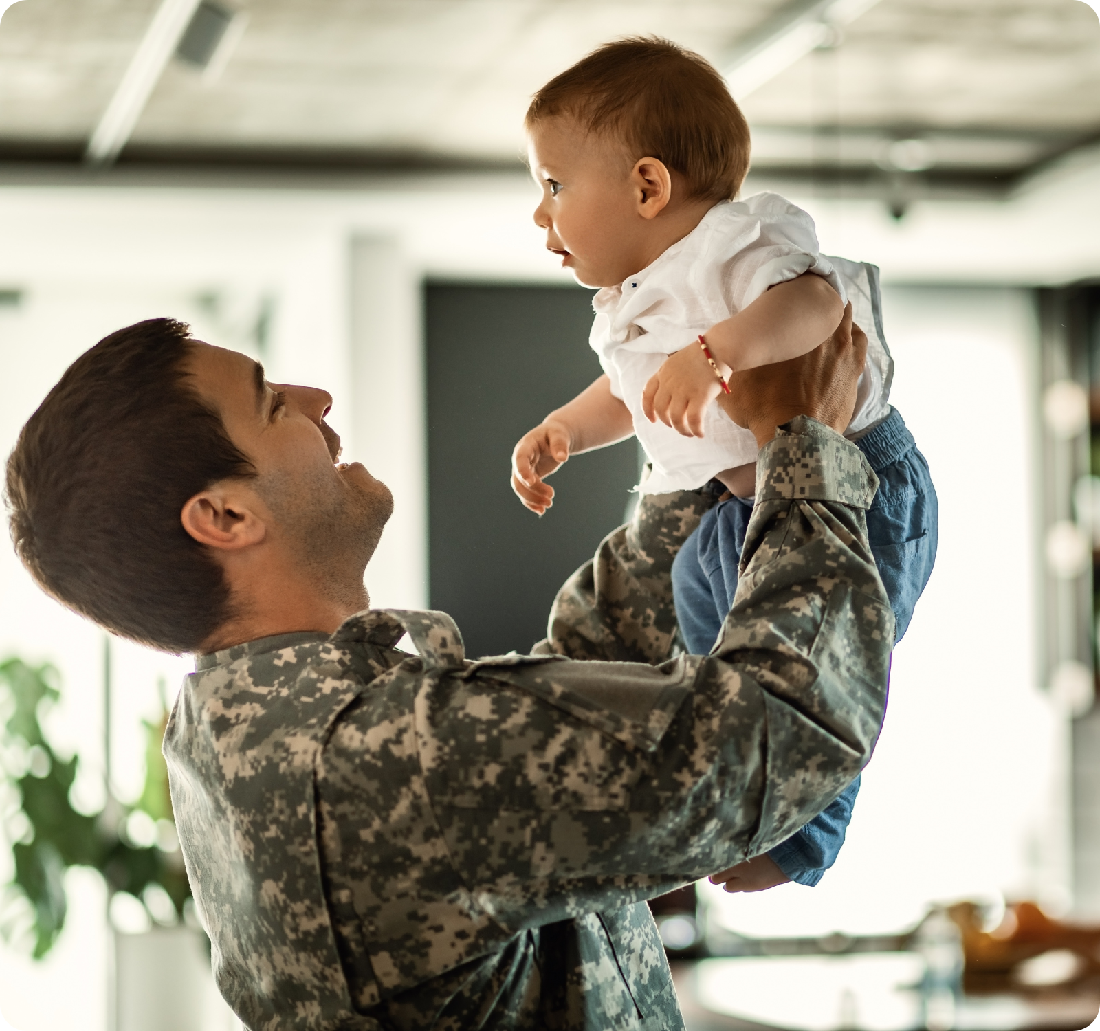 veteran smiling and holding up his baby daughter