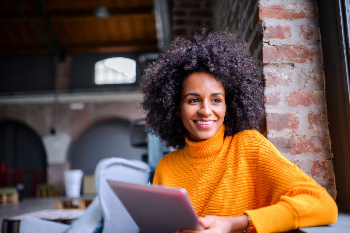 Woman holding iPad and smiling