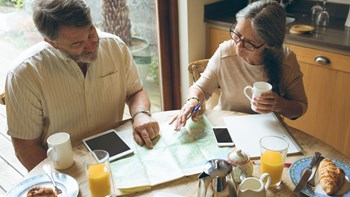 Man and woman looking at map over breakfast
