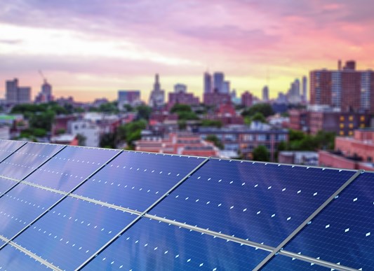 Solar panels in front of a city skyline