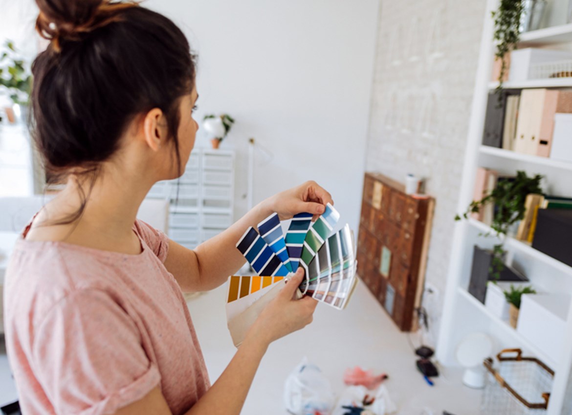 Woman looking at color options for painting a wall