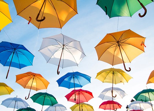 Colorful umbrellas floating in sky