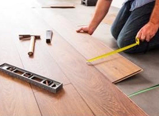 Construction worker measuring floorboards