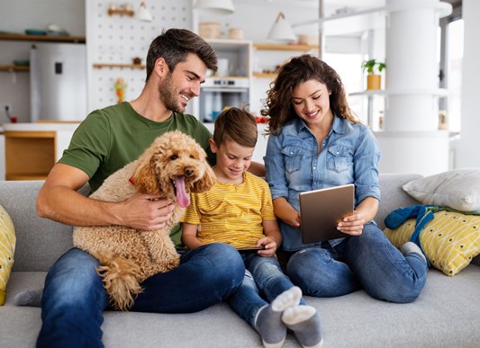 Happy family with dog looking over list on iPad