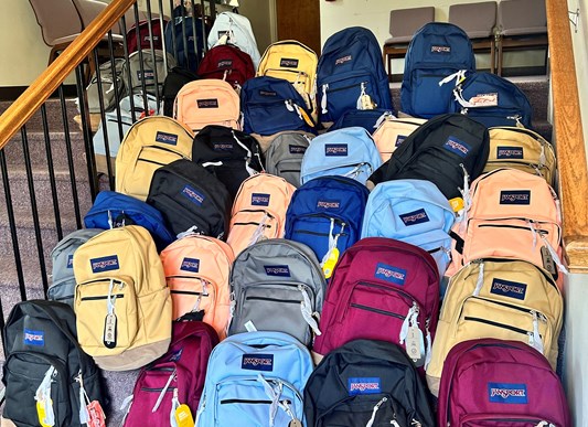 A staircase with stacks of backpacks